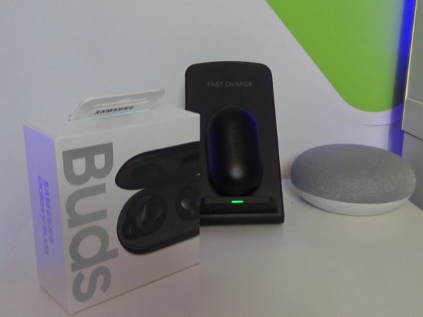 A picture of the Galaxy Buds box alongside the Buds themselves on a wireless charger